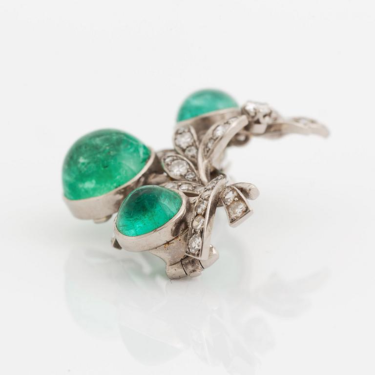 A WA Bolin brooch in 18K white gold set with a cabochon-cut emerald and eight-cut diamonds.