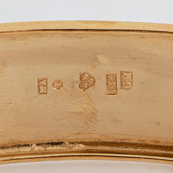 An 18K gold bangle.