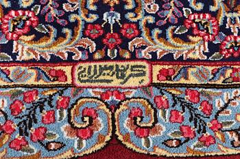 An old Kerman carpet, signed, c. 290 x 208 cm.