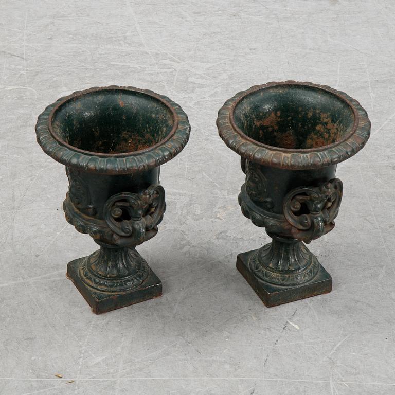 A pair of cast iron garden urns.