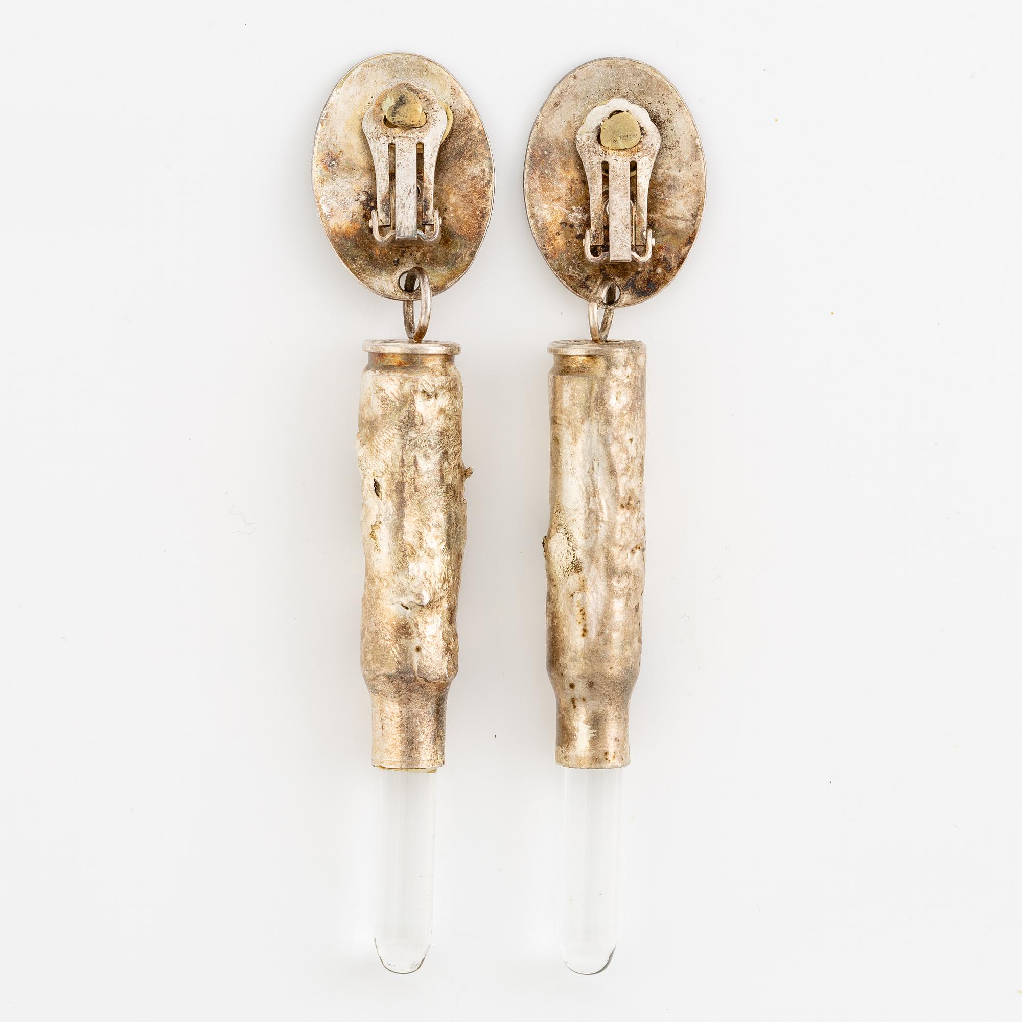 Earrings, possibly Slim Barrett.