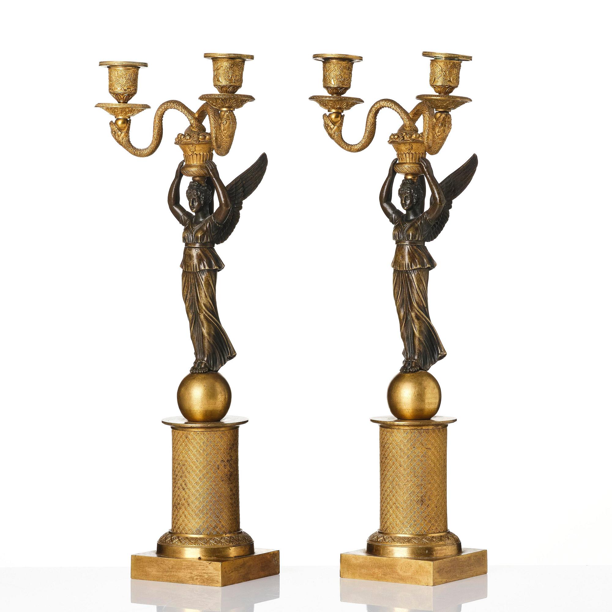 A pair of gilt and patinated bronze Empire-style two branch candelabra, later part 18th century.