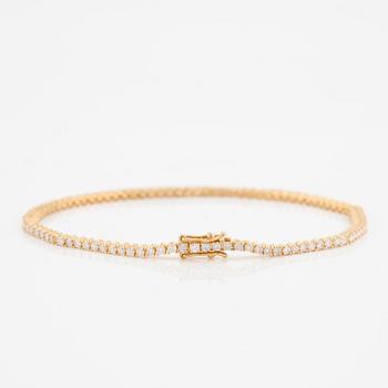 A tennis bracelet in 14K gold with round brilliant-cut diamonds.