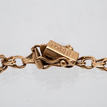 An 18K gold bracelet with a charm.
