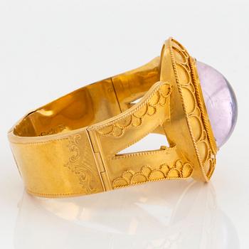 An 18K gold bracelet set with a cabochon-cut amethyst.