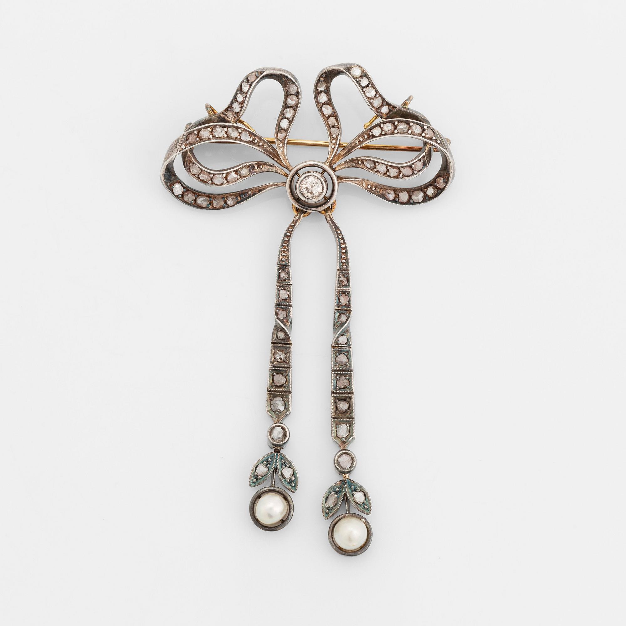 A 14K gold and silver brooch set with old- and rose-cut diamonds and two pearls.