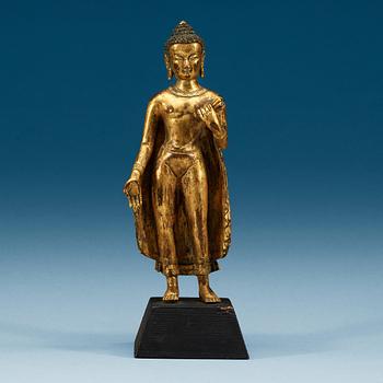 A standing gilt bronze figure of Buddha, Nepal, 19th Century.