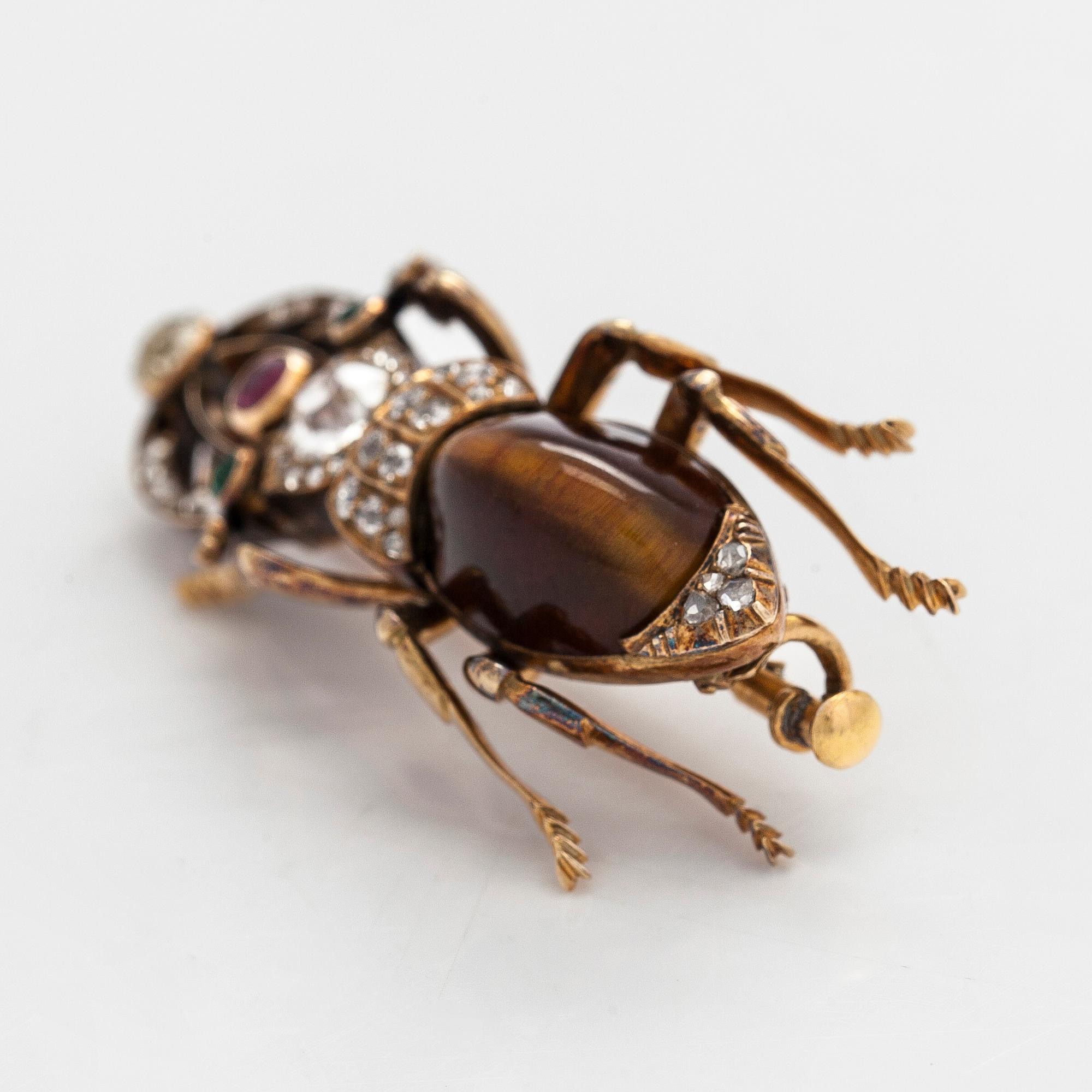 A 14K gold brooch with tiger’s eye, old-cut and rose-cut diamonds, ruby, emeralds. St. Petersburg.