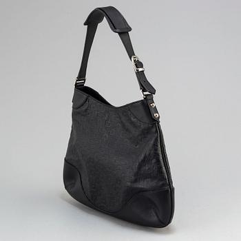 GUCCI, a black leather handbag.