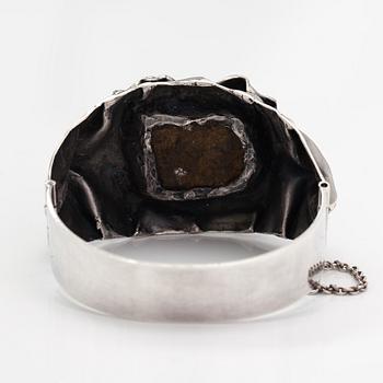 Reino Saastamoinen, Armband "Maahiset", sterlingsilver och ametist. Helsingfors 1971.