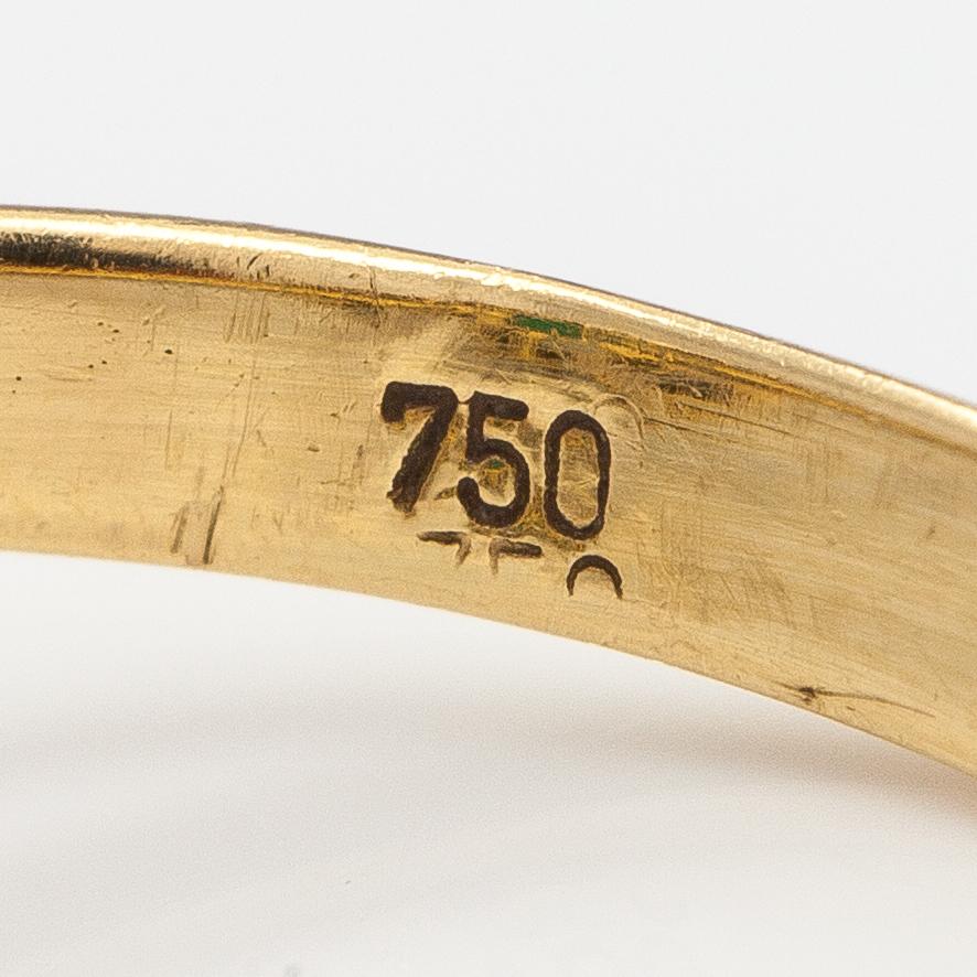 An 18K gold ring with diamonds ca. 0.21 ct and an emerald.