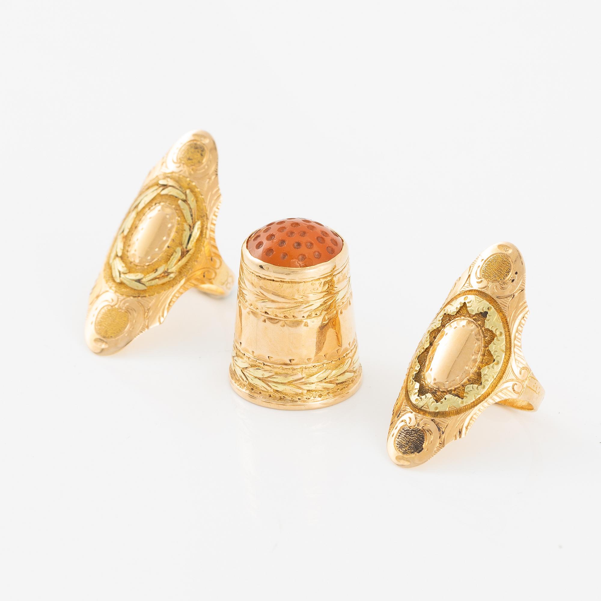 Thimble, finger guard and two rings, 18K gold, with fitted case.