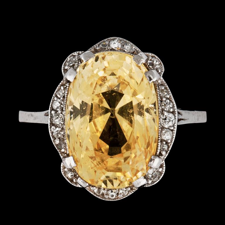 A ring with a yellow sapphire circa 9.40 cts surrounded by old-cut diamonds.