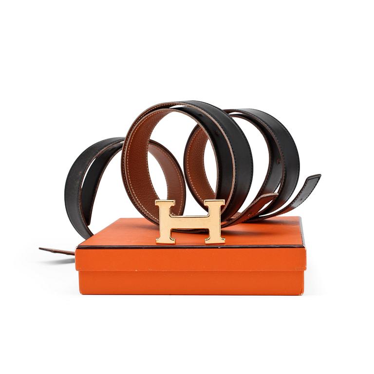 HERMÈS, four reversible belts, black and brown with gold coloured H belt buckle.