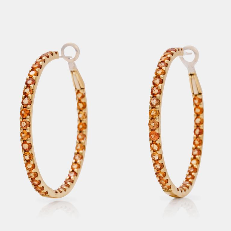 A pair of orange-yellow sapphire hoop earrings.
