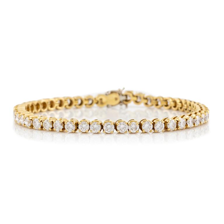 A tennis bracelet in 14K gold with round brilliant-cut diamonds.