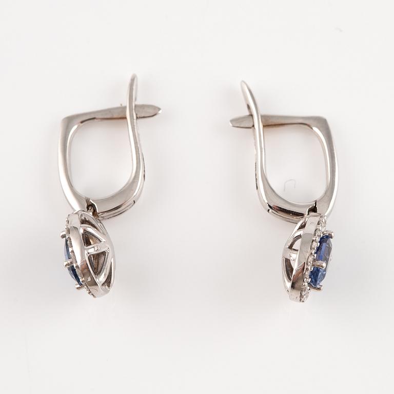 A pair of 14K gold earrings with faceted sapphires and round brilliant-cut diamonds.