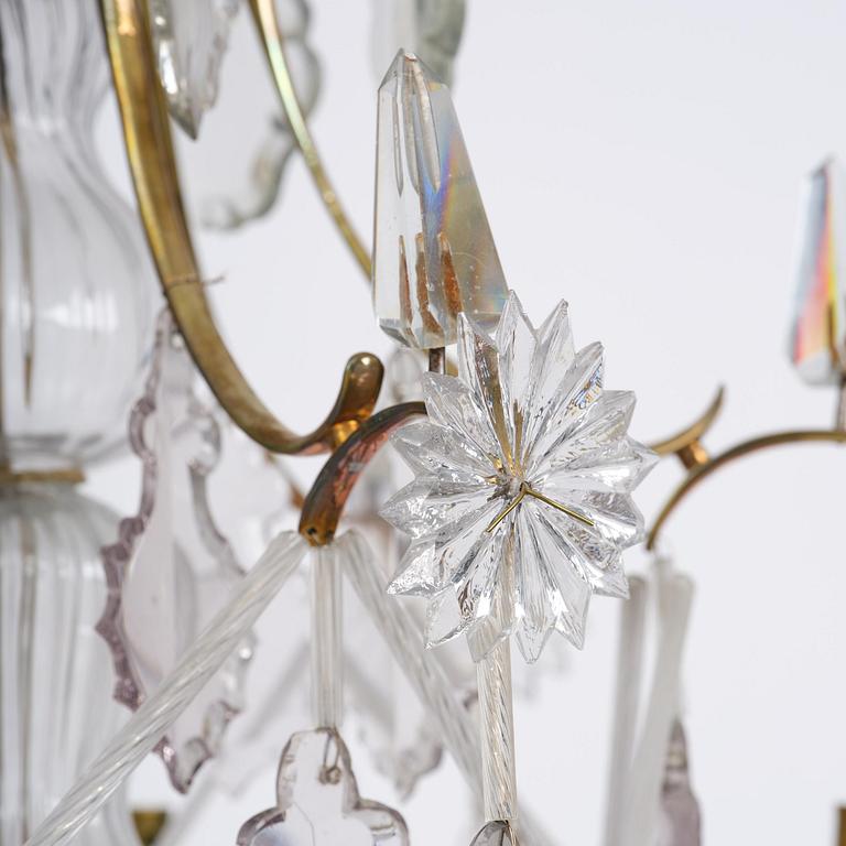 A near pair of rococo-style gilt brass and cut glass six-branch chandeliers, 19th century incorporating older elements.