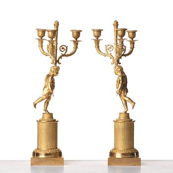 A pair of French Empire early 19th century three--light candelabra.