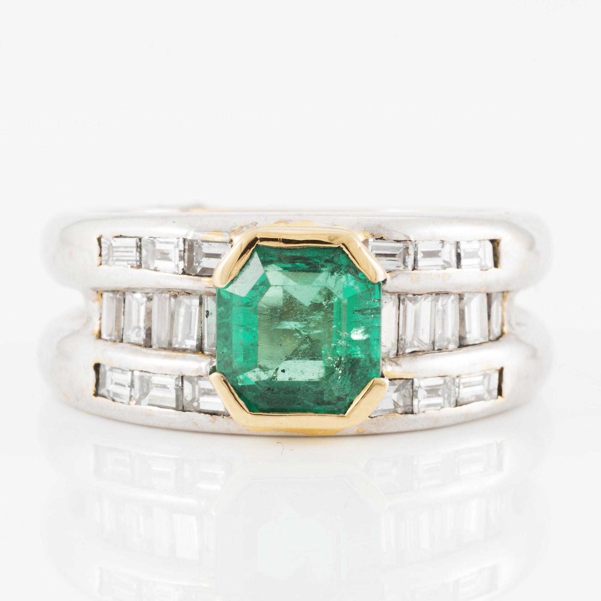 A ring in 18K gold set with a faceted emerald and baguette-cut diamonds.