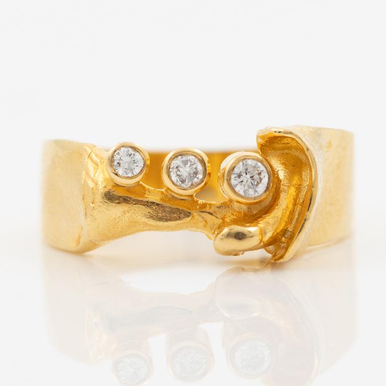 Ring in 18K gold set with three brilliant-cut diamonds.