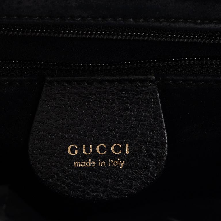 Gucci, a black leather and bamboo bag.