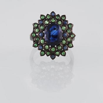 RING, 18K guld med fasettsliapde blå safirer ca 0.18 ct, kyanit ca 2.88 ct samt demantoider ca 0.60 ct. Vikt 6,2 gram.