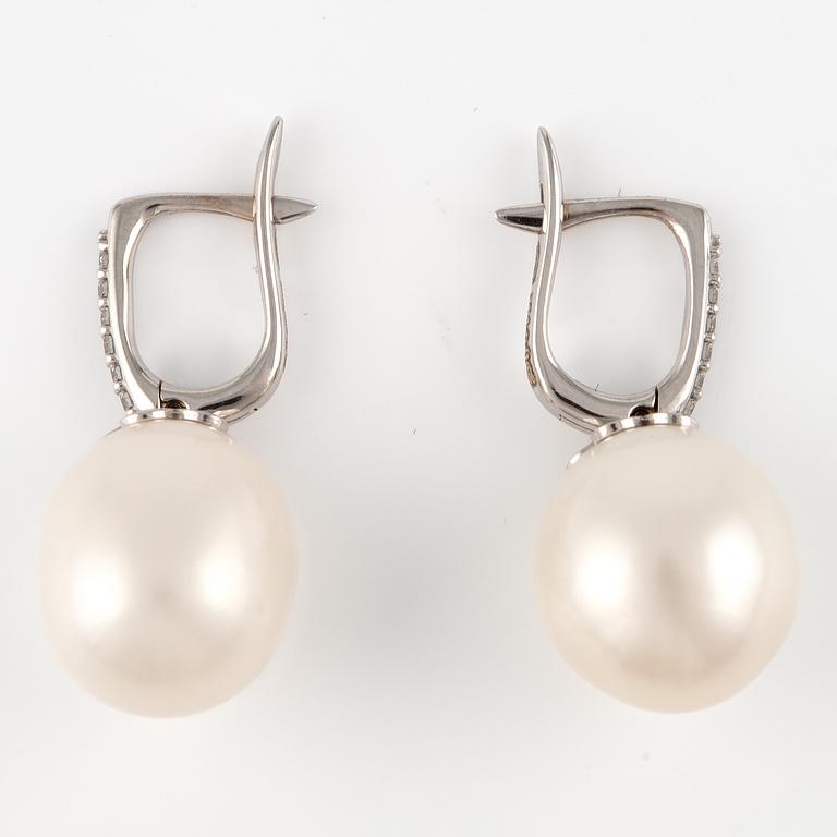 A pair of 18K gold earrings with cultured freshwater pearls and round brilliant-cut diamonds.