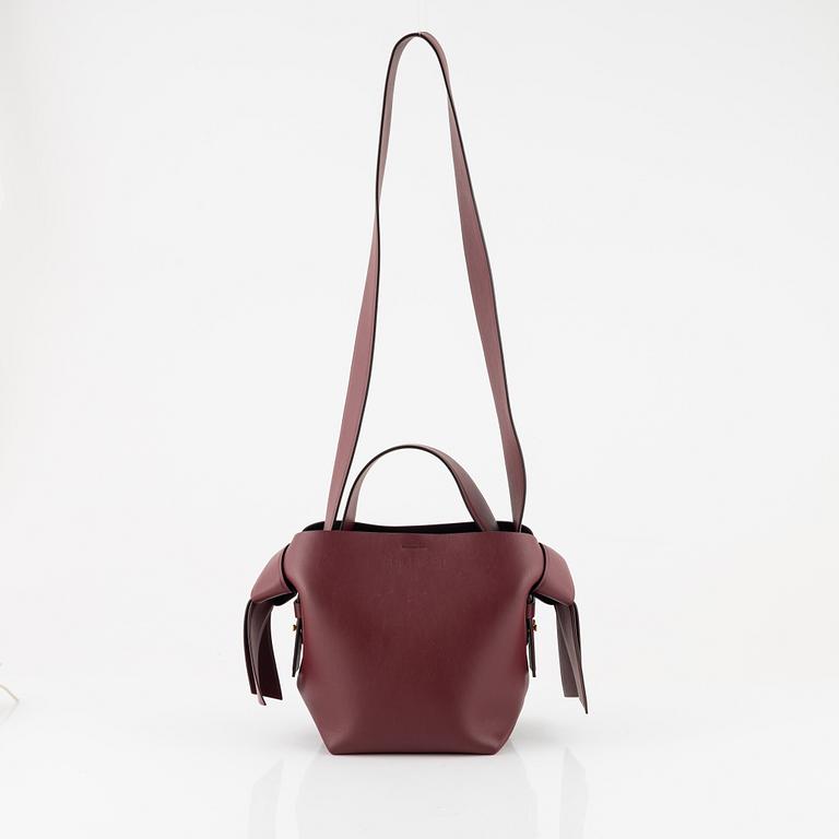 Acne Studios, a burgungy leather 'Musubi Mini' handbag.