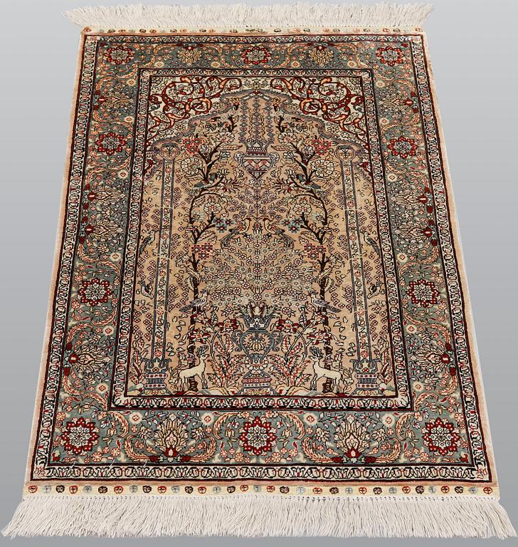 An oriental silk rug, approx. 95 x 63 cm.