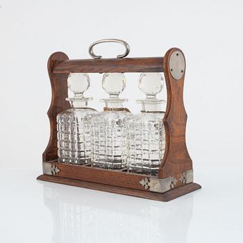 A mahogany and electroplate tantalus witht three carafes, circa 1900.