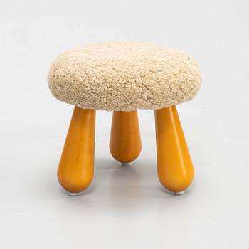 A Swedish, new produced stool with birch legs and sheepskin upholstery.