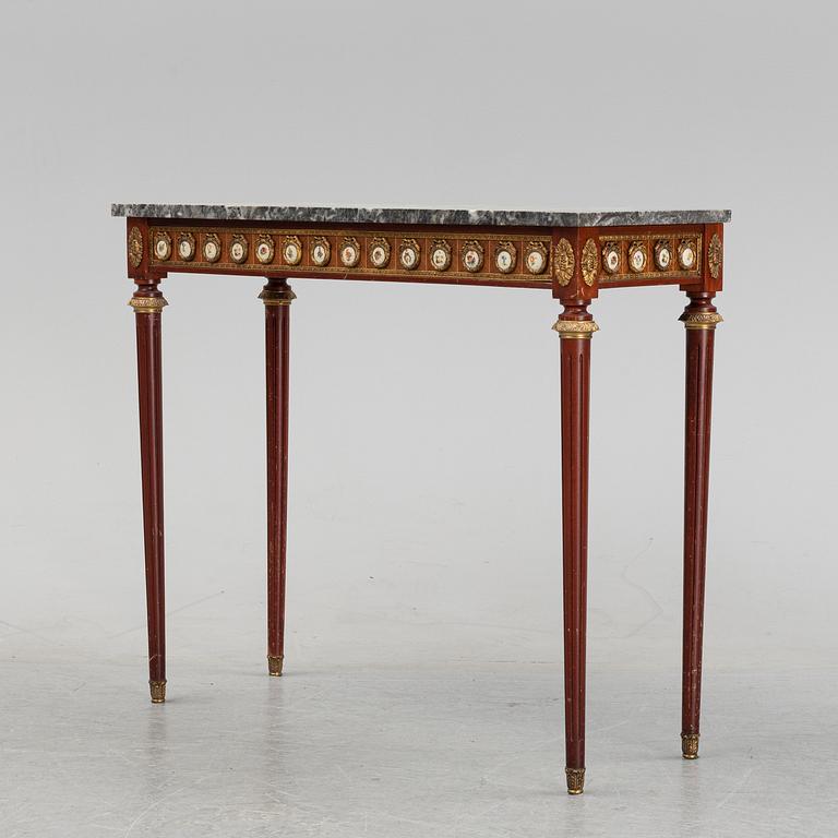 A Louis XVI style console table with a marble top.