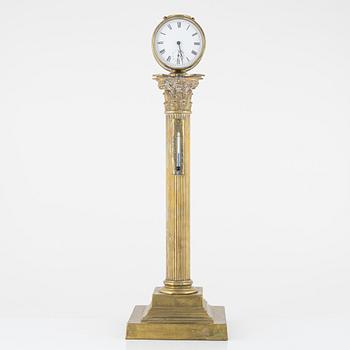A table clock with a thermometer, around the year 1900.