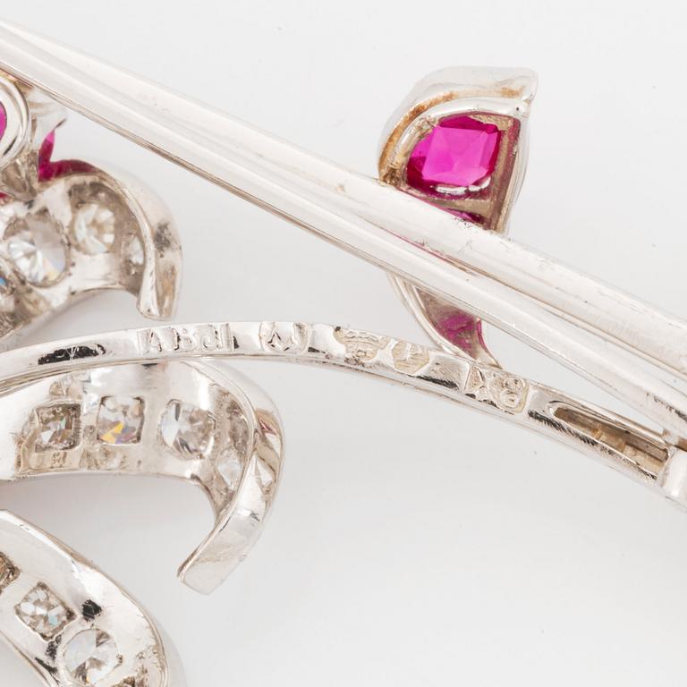 Brosch platina med fasettslipade rubiner och runda briljant- och åttkantslipade diamanter.