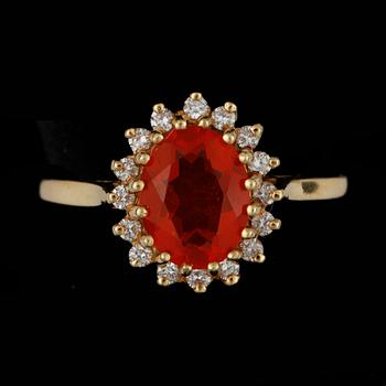 RING, 18k guld med eldopal och krans av 16 små briljantslipade diamanter, tot ca 0,16 ct. Vikt ca 4 gram.