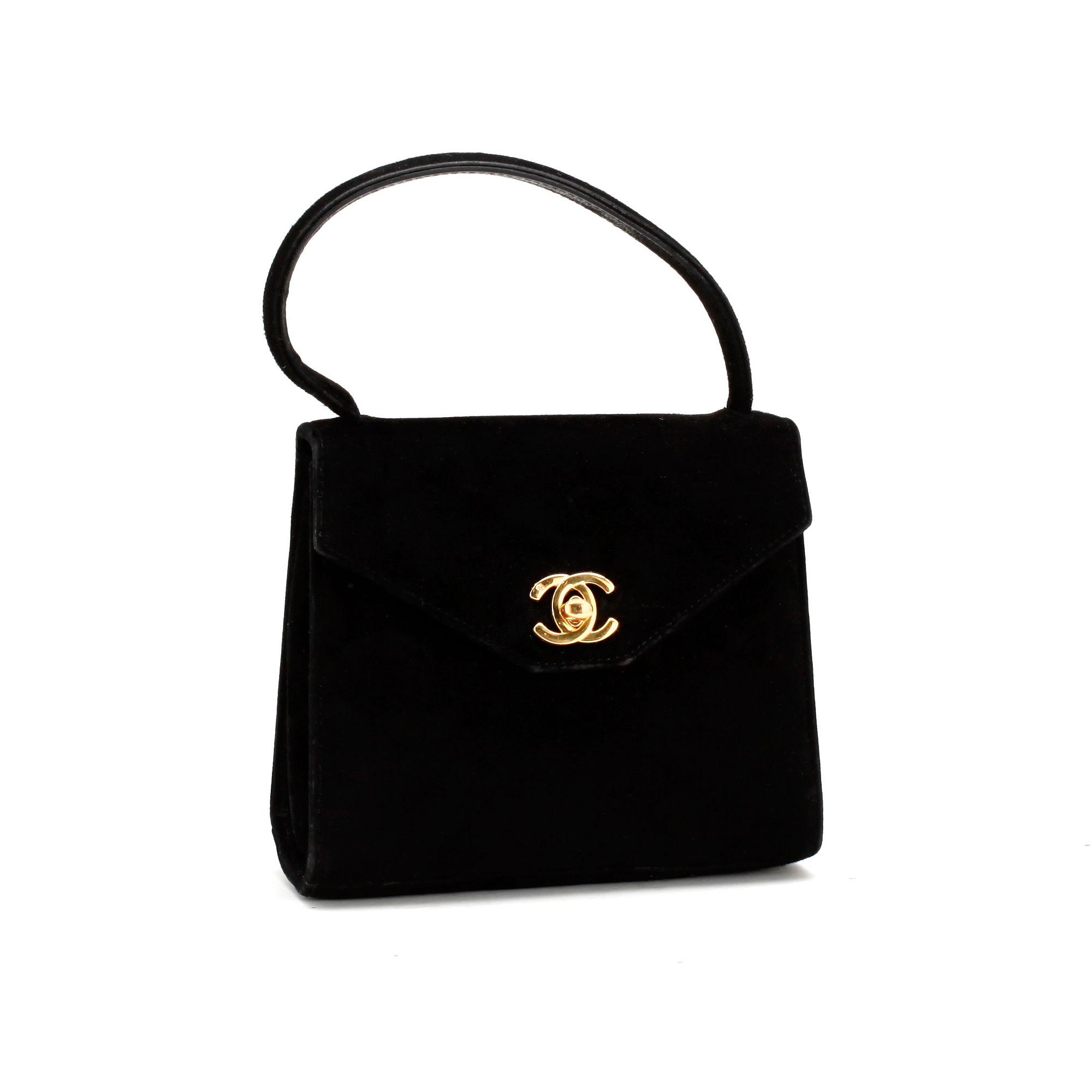 CHANEL, a black suede evningbag with a CC adorned lock.