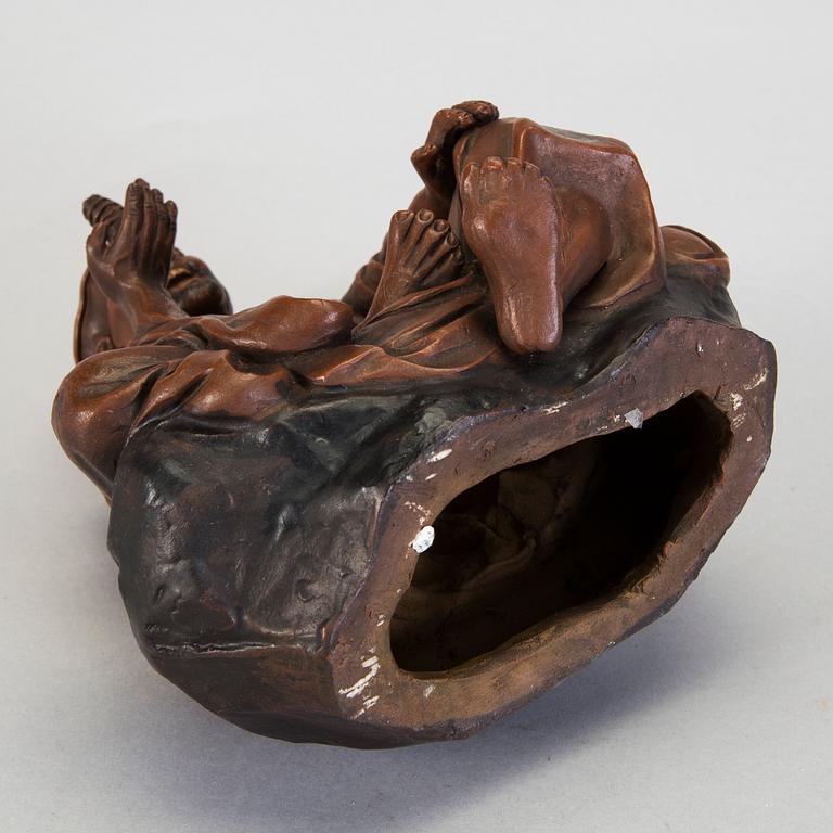 A Japanese earthenware seated figure of a man holding a pagoda, 20th century.