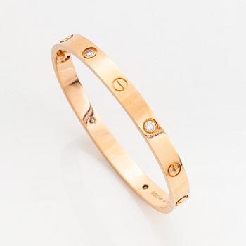 A Cartier "Love" bracelet in 18k rose gold set with four round brilliant-cut diamonds.