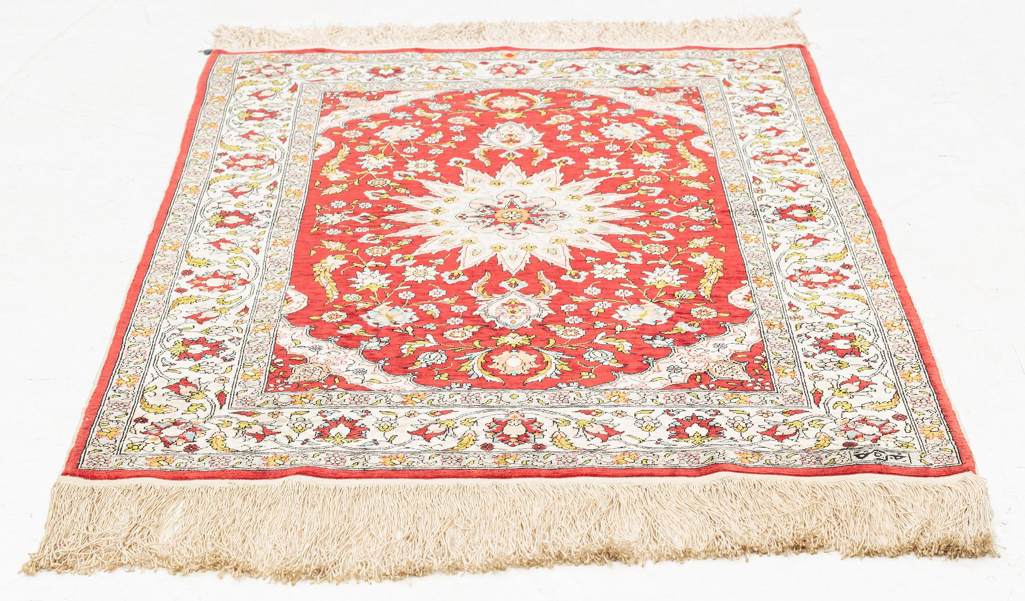 A silk Hereke rug, circa 91 x 63 cm.