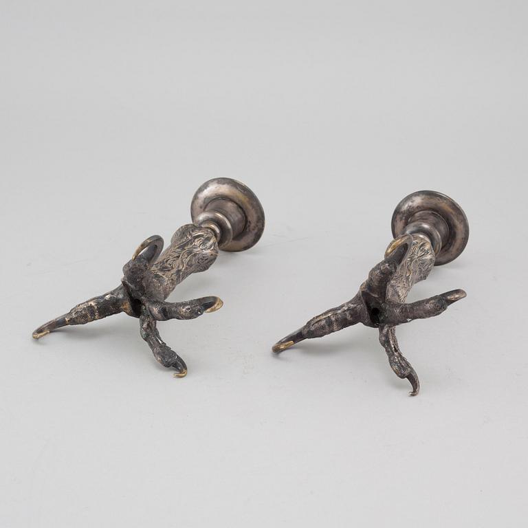 A pair of silvered metal candlesticks, around the year 1900.