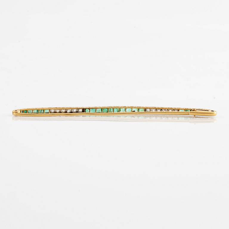 Brosch, längre modell, guld med carréslipade smaragder och gammalslipade diamanter, troligen omkring sekelskiftet 1900.