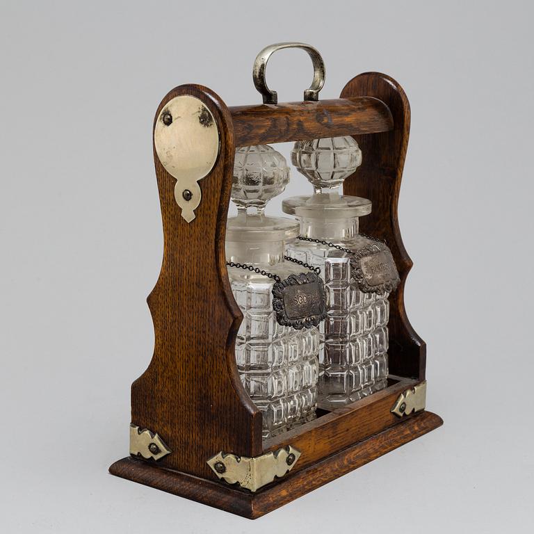 An oak, silver, silverplated and glass tantalus with lock. Second half of the 20th century.