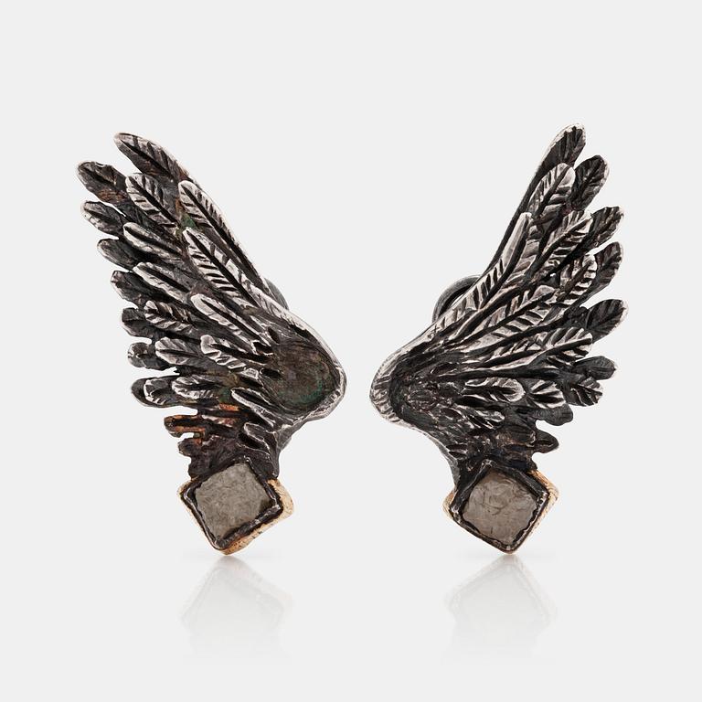 A pait of wing shaped earrings set with un cut diamonds buy Torben Hardenberg.