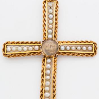 An 18K gold and pearl cross pendant with a gold chain.