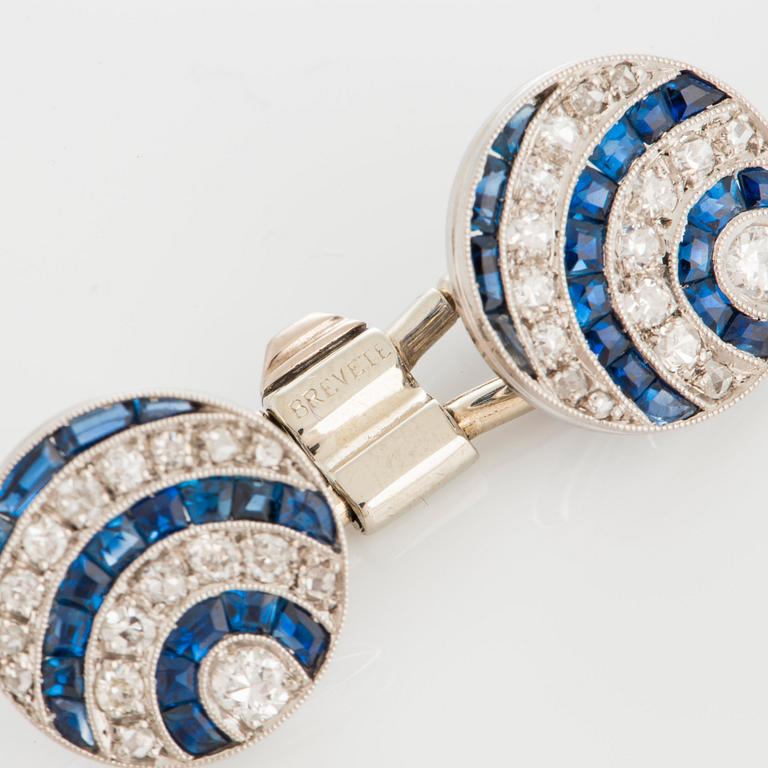 A pair of cufflinks in platinum and 18K white gold set with diamonds of various cuts and sapphires.