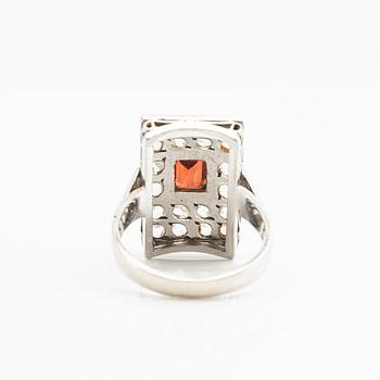 Ring, 18K white gold with a red stone (possibly garnet) and diamonds.