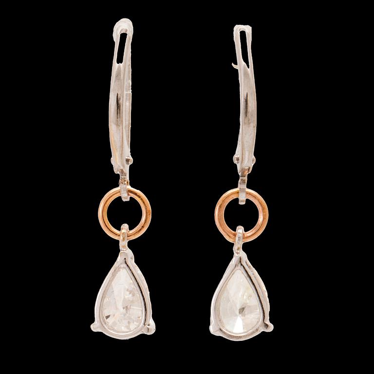 A pair of 18K white and rose gold earrings set with pear cut diamonds.