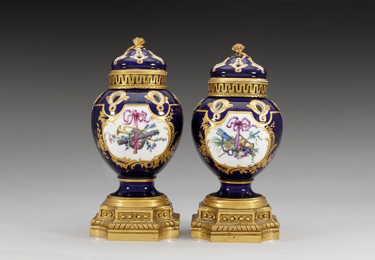 A pair of gilt bronze mounted Sevres pot-pourri jars with covers, 18th Century. (2).