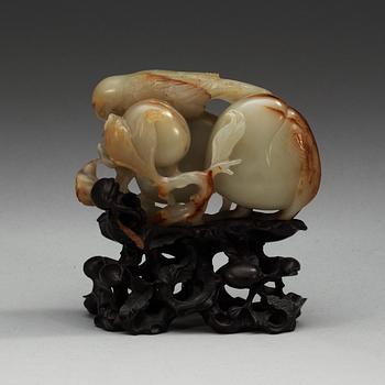 A carved nephrite figure of a parrot among peaches, Qing dynasty.